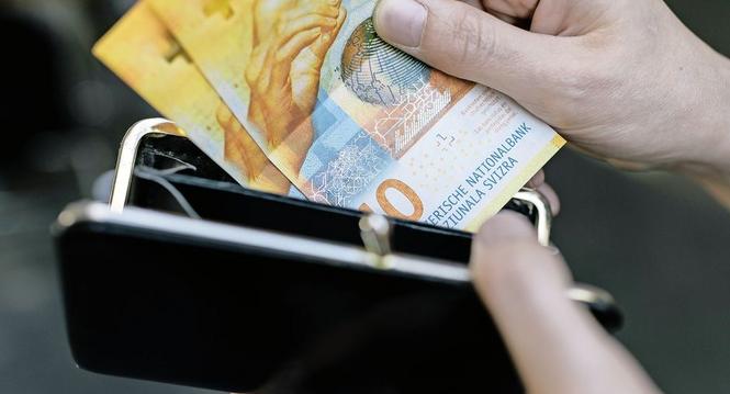 Eine Person entnimmt eine Zehnernote aus ihrem Portemonnaie, aufgenommen am 18. Oktober 2017 in Zuerich.